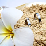 Wedding rings nestled in the sand, symbolizing love and commitment on a romantic Seychelles honeymoon.