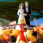 A wedding cake adorned with couple figurines, symbolizing love and celebration in a Seychelles honeymoon setting.