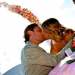 A bride and groom share a romantic kiss on a picturesque beach, celebrating their wedding in the Seychelles during their honeymoon.