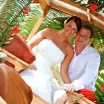 A bride and groom in a wooden carriage, celebrating their wedding in the picturesque Seychelles, perfect for a honeymoon.
